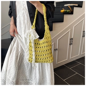 Detail of yellow woven bucket bag featuring an oversized white lace floral bow decoration