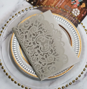 Close-up of laser-cut hollow pattern on pearlescent champagne wedding invitation card