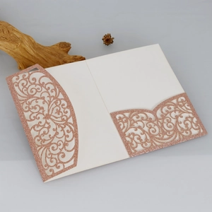 Détail de motifs de vigne découpés au laser et pochettes à paillettes or rose sur carte