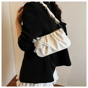 Détail du sac à bandoulière en similicuir plissé blanc avec pendentif nœud perlé