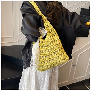 Detail of yellow hand-woven crochet bucket bag with elegant white lace ribbon on handle