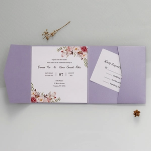Detail of purple tri-fold wedding invitation set with floral design and RSVP insert card