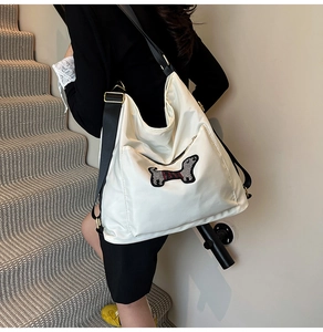 Detailed shot of a white nylon tote bag featuring a cute dachshund embroidery patch