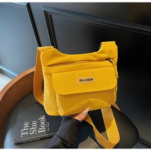 Dettaglio di una borsa a tracolla in tela giallo brillante con cinturino largo