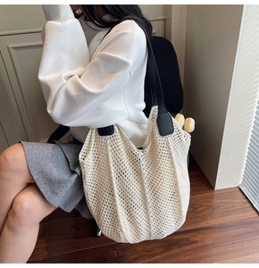 Vue détaillée du sac cabas en maille beige avec bandoulière en cuir noir et décor de tulipe