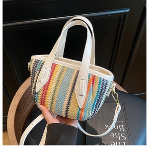 Détail du sac seau tissé à rayures colorées avec bordure en similicuir blanc et garniture dorée