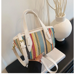 Détail du sac seau tissé coloré avec poignées en cuir blanc et boucles en métal doré