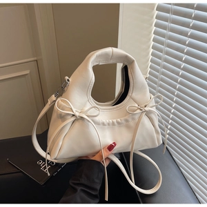 Détail d'un sac à main blanc forme nuage avec nœuds et fine bandoulière réglable