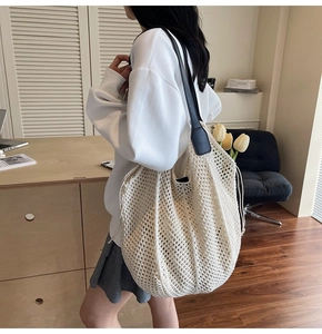 Détail du grand sac cabas en crochet blanc ajouré avec des anses en cuir noir et cordon