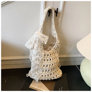 Detail of cream woven bucket bag with lace scarf detail and drawstring inner pouch
