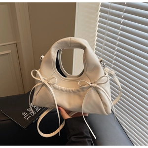 Vue détaillée du sac à main en cuir blanc brillant avec double nœuds coulissants élégants