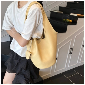 Detail of light yellow lychee grain leather tote bag with matching small coin purse pendant