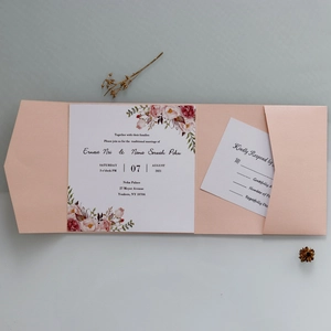Detail view of pearl pink wedding invitation set with floral patterns and RSVP cards