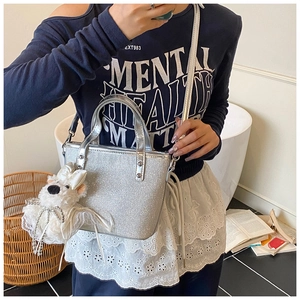 Silberne Pailletten-Beuteltasche mit Plüsch-Hundeanhänger in gemütlicher Innenraum-Szene