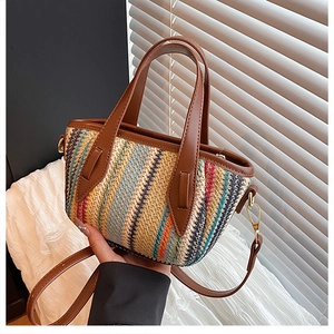 Détail d'un sac seau tissé à rayures zigzag avec anses en cuir et boucles dorées