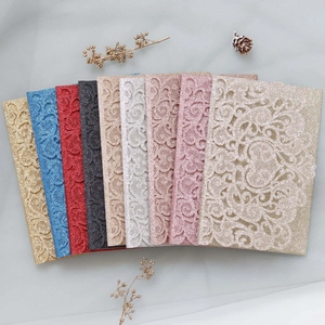 Close-up of laser-cut glitter paper wedding invitations in nine metallic and classic colors