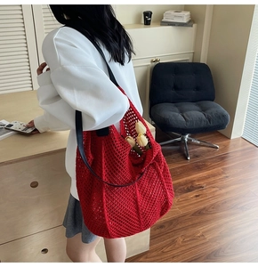 Détail d'un sac cabas au crochet rouge avec maille évidée et fine bandoulière noire