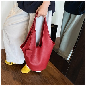 Detail of red pebbled leather bucket bag showing its elegant texture and round silhouette