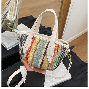 Détail du sac seau en paille tissée colorée avec bordure en similicuir blanc et boucles