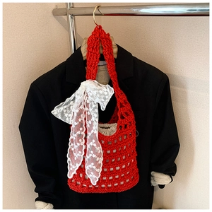 Close-up of red woven bucket bag with large white lace bow detail and inner pouch