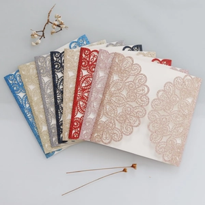 Macro detail of laser-cut glitter paper invitations in various metallic colors