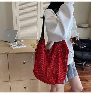 Gros plan du sac à bandoulière en maille rouge tressé avec bandoulière en cuir noir