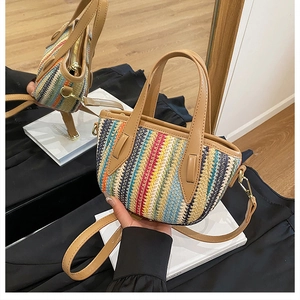 Détail du sac en paille à rayures colorées avec texture tressée et anse en cuir marron