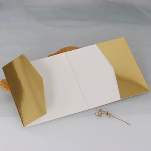 Detail of dark green wedding invitation with gold mirror finish and slanted flap design