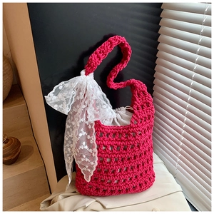 Detailed macro view of magenta woven bucket bag with lace bow and canvas drawstring liner