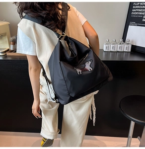 Detail of cute black cartoon puppy backpack featuring wide straps and spacious design