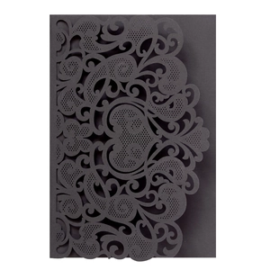 Close-up of black laser-cut paisley heart wedding invitation cover with intricate floral patterns