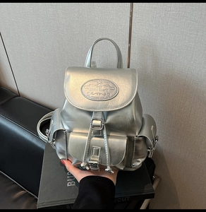 Détail du sac à dos argenté métallisé avec logo embossé et fermeture à cordon coulissant