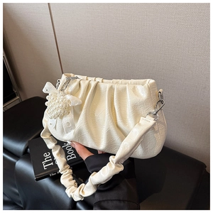 Detail of off-white pleated cloud bag with pearl grape charm and ruffled strap