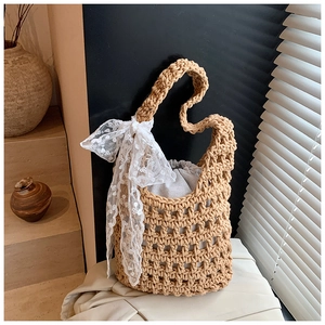 Detail of woven straw bucket bag showing lace bow and secure inner drawstring liner