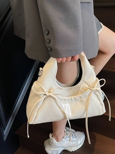 Sac à main blanc crème en cuir verni brillant avec nœuds pour un look femme élégant