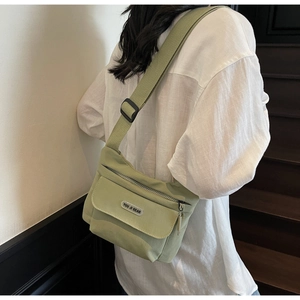 Dettaglio della borsa a tracolla in nylon verde chiaro con tasca a patta e tracolla regolabile