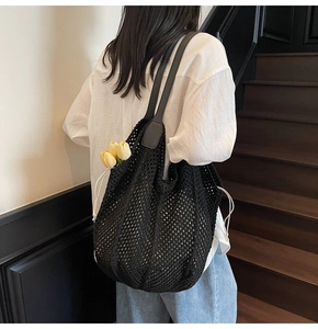 Detailansicht der Rückseite einer schwarzen handgewebten Netztasche mit Lederriemen