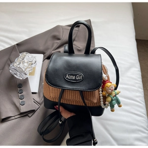 Details des Mini-Patchwork-Rucksacks mit Metalllogo und niedlichem Cartoon-Puppenanhänger