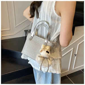 Nahaufnahme der silbernen Strass-Beuteltasche mit einem niedlichen Plüschwelpen-Anhänger