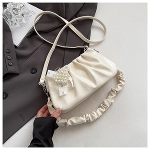 Close-up of off-white gathered handbag with pearl heart charm and lace ribbon detail