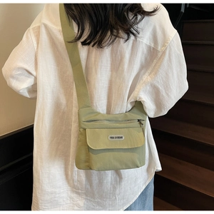 Borsa a tracolla in tela verde indossata da modella per stile casual quotidiano