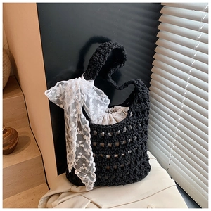 Detail of hand-woven black hollow tote bag with beige drawstring lining and lace ribbon