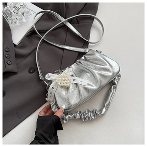 Detailed shot of silver pleated bag featuring pearl lace heart and ruched handle texture