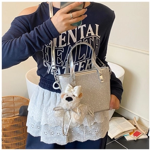 Spiegel-Selfie der silbernen Glitzer-Eimertasche mit Plüschbär-Anhänger und Metallgriff