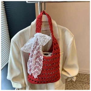 Detail of red crochet bucket bag with large white lace bow and drawstring liner