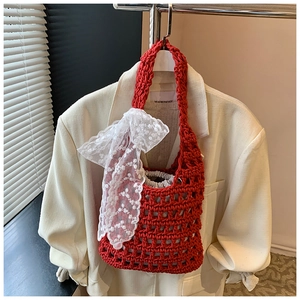 Detail of red crochet tote bag with large white lace bow and gray drawstring liner