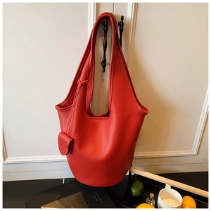 Detailed view of red pebble leather bucket bag with matching small coin pouch accessory
