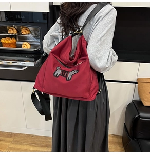 Detail of red nylon backpack featuring a sequined striped dachshund pattern on the back