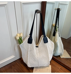 Détail du sac fourre-tout en maille tressée blanche avec finitions en cuir noir élégant