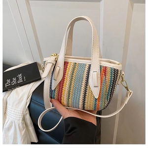 Détail du mini sac seau tissé coloré avec poignées en similicuir blanc et fermoir doré